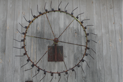 A HAYRAKE RE-PURPOSED AS A SUNDIAL SCULPTURE.